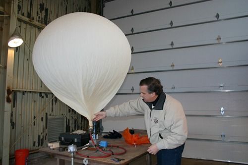 Fig. 3—A meteorologist fills a balloon in preparation for launch. (NWS photo).